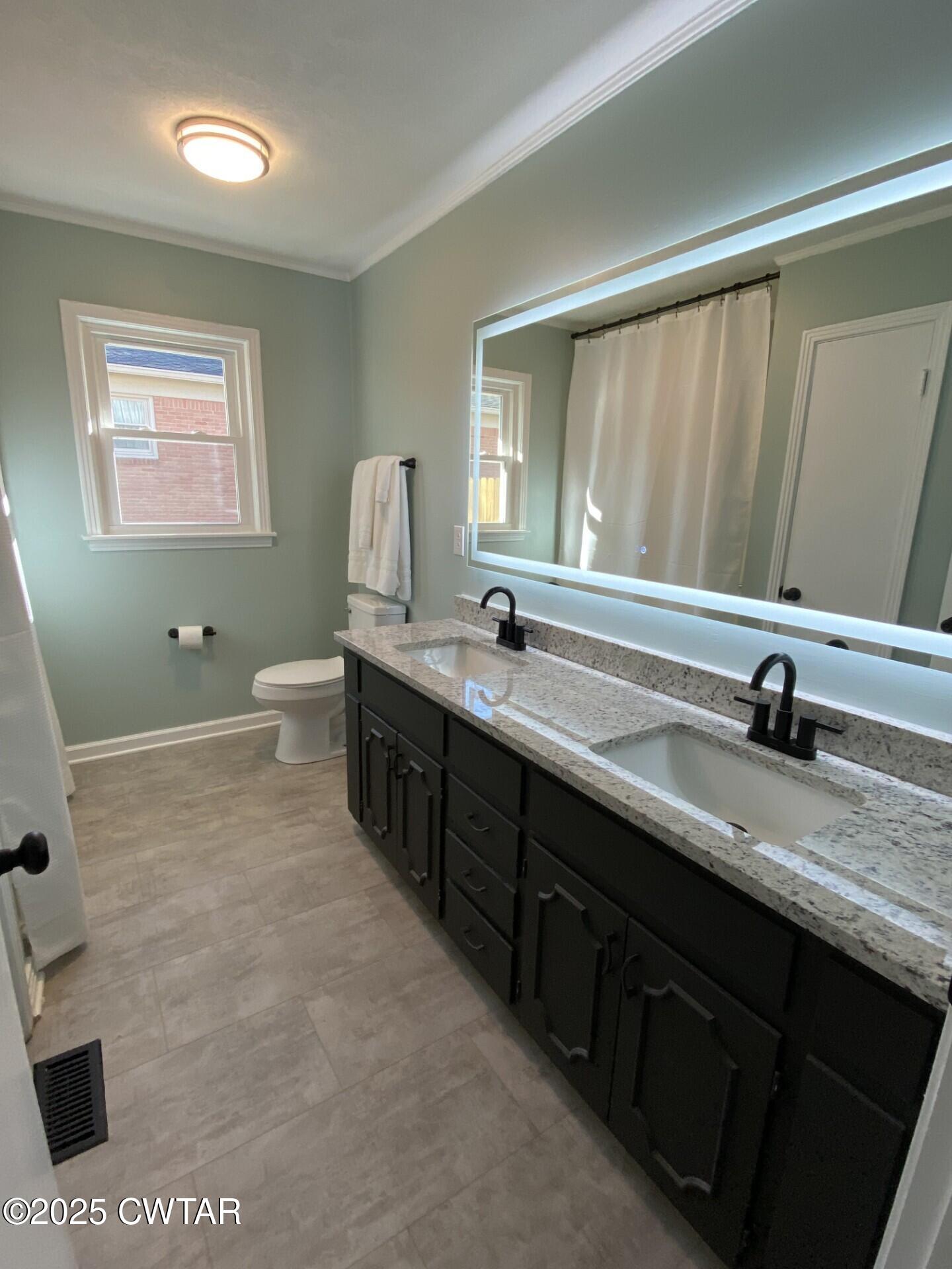 208 4th Street Henderson, TN 38340 - Photo 52 of 62 a spacious bathroom with a granite countertop sink a mirror and a