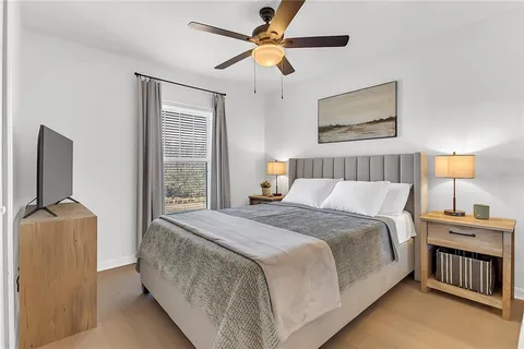 a bedroom with a bed and a flat tv screen on dresser