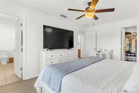 a bedroom with a bed tv and a chandelier