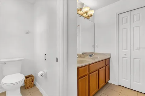 a bathroom with a granite countertop sink a toilet and a mirror