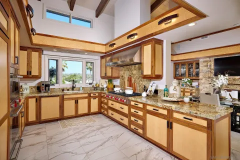 a large kitchen with stainless steel appliances granite countertop a large counter top a stove a sink and a refrigerator