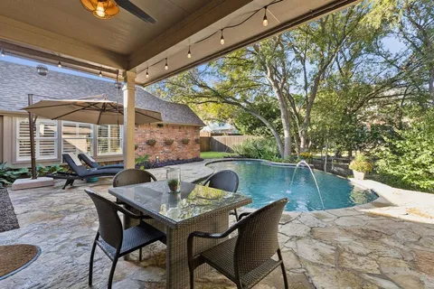 a view of a yard in front of a house with large trees