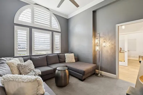 a living room with furniture fireplace and large windows