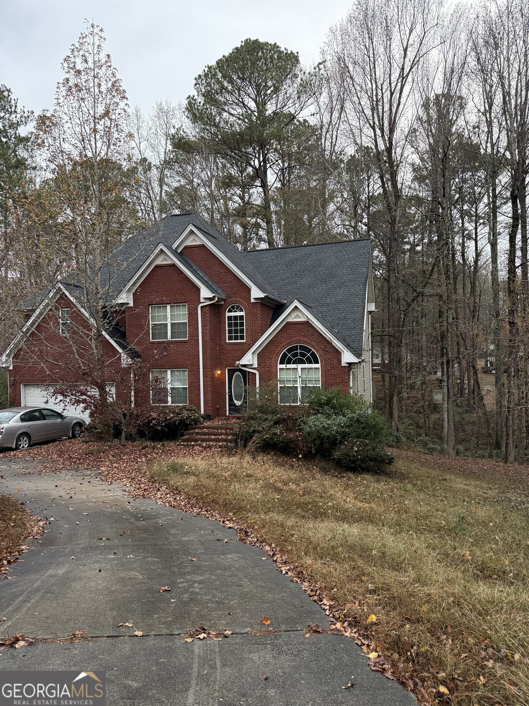a front view of a house with a yard and trees