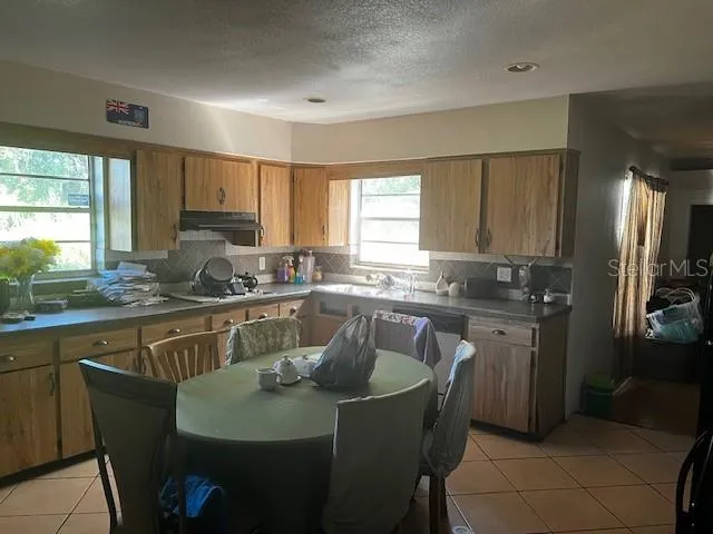 a kitchen with kitchen island granite countertop a sink cabinets and window