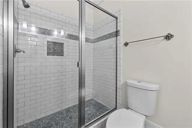 a bathroom with a toilet and a shower
