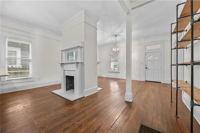 a view of a livingroom with wooden floor and a fireplace