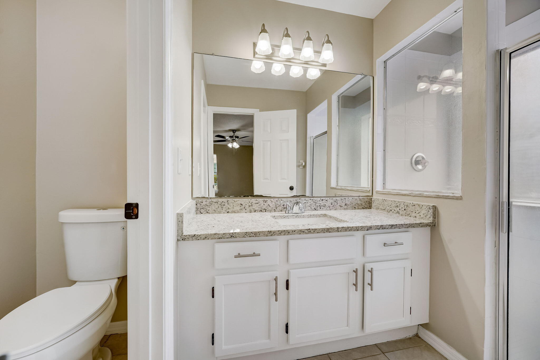 1092 Thompson Road Southwest Palm Bay, FL 32908 - Photo 13 of 17 a bathroom with a granite countertop toilet a sink and a mirror