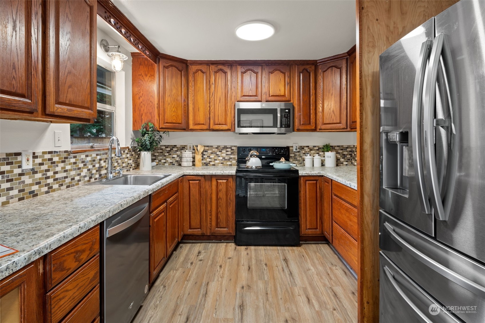 432 170th Place Southwest Bothell, WA 98012 - Photo 9 of 30 a kitchen with stainless steel appliances granite countertop a refrigerator a sink dishwasher a stove top oven a refrigerator with cabinets and wooden floor
