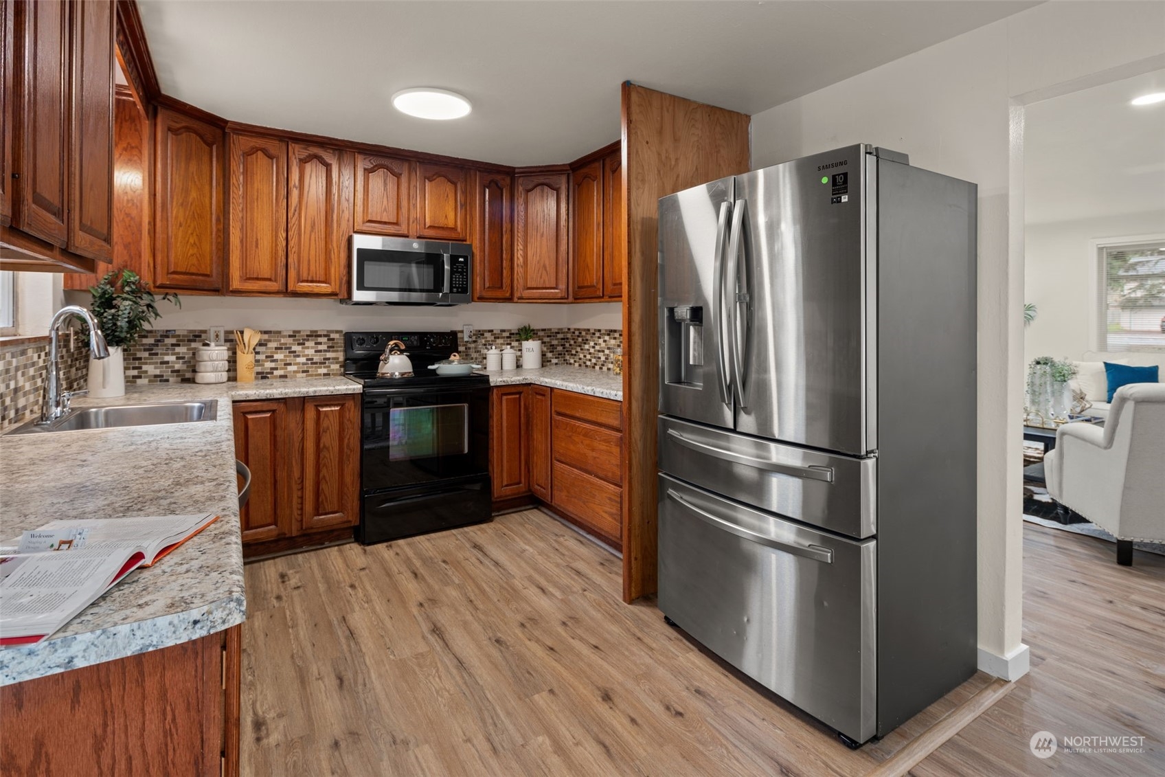 432 170th Place Southwest Bothell, WA 98012 - Photo 10 of 30 a kitchen with stainless steel appliances granite countertop a refrigerator stove a sink dishwasher and wooden cabinets with wooden floor