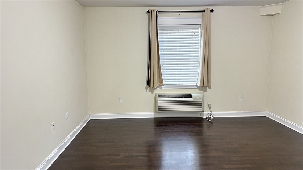 39 Fayette Street, Unit 102 Quincy, MA 02171 - Photo 13 of 24 an empty room with wooden floor and windows