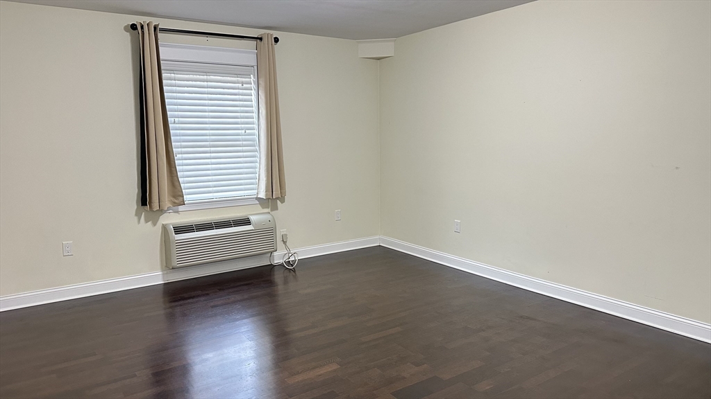 39 Fayette Street, Unit 102 Quincy, MA 02171 - Photo 14 of 24 an empty room with wooden floor and windows