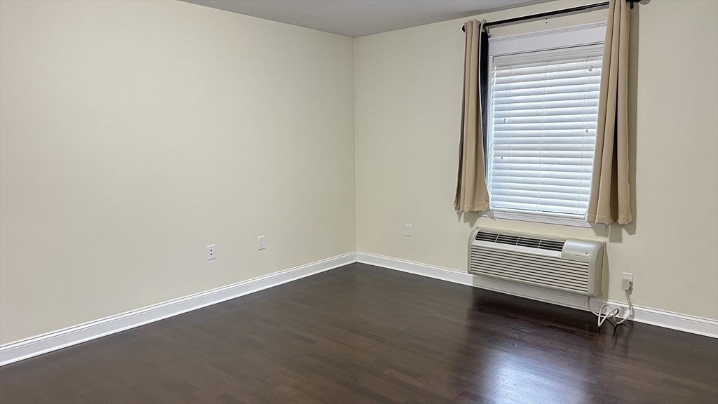 39 Fayette Street, Unit 102 Quincy, MA 02171 - Photo 15 of 24 an empty room with wooden floor and windows