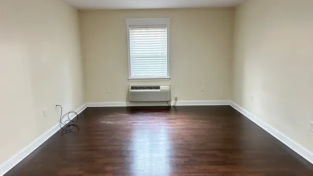 a view of a room with wooden floor and a window