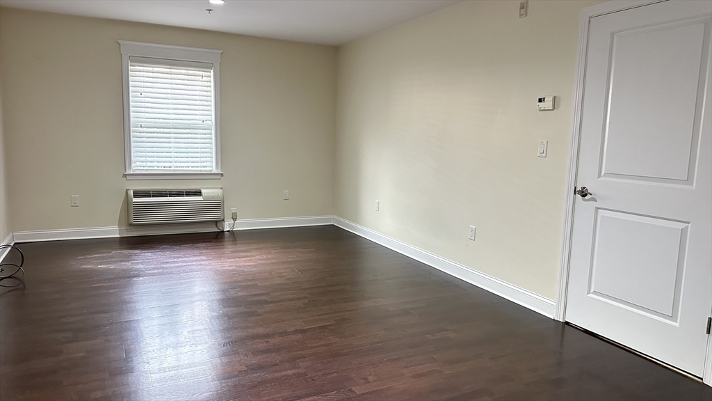 39 Fayette Street, Unit 102 Quincy, MA 02171 - Photo 22 of 24 an empty room with wooden floor and windows