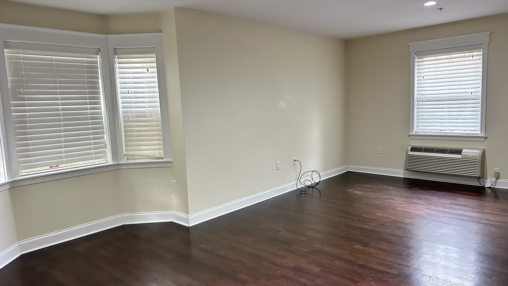 39 Fayette Street, Unit 102 Quincy, MA 02171 - Photo 23 of 24 an empty room with wooden floor and windows