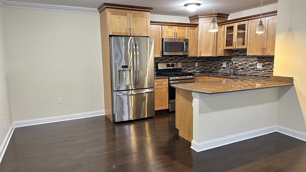 39 Fayette Street, Unit 102 Quincy, MA 02171 - Photo 6 of 24 a kitchen with stainless steel appliances granite countertop a refrigerator a sink and white cabinets