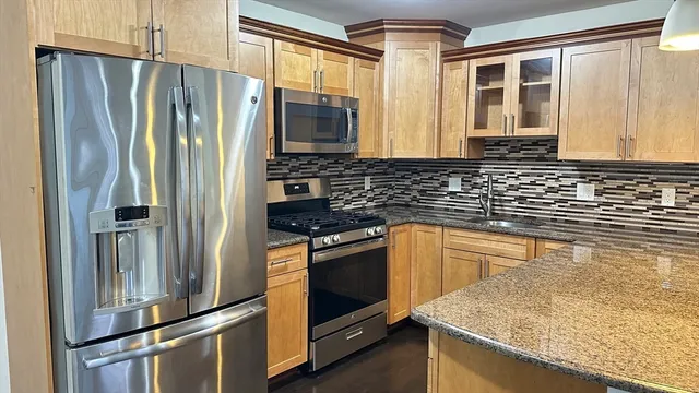 a kitchen with stainless steel appliances granite countertop a refrigerator and a sink