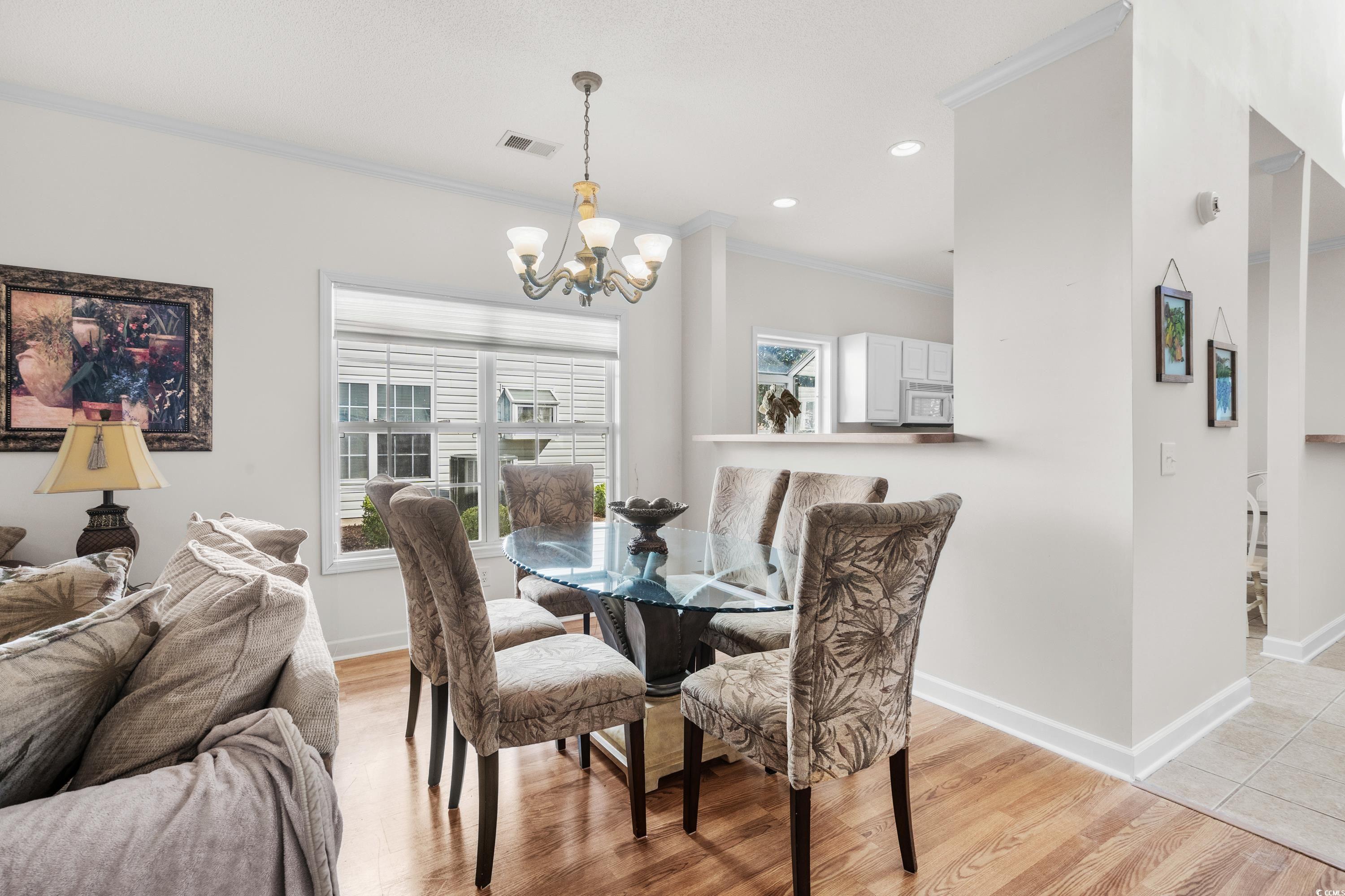 493 Shellbank Drive, Unit 2B Longs, SC 29568 - Photo 19 of 40 Dining space featuring crown molding, light hardwo