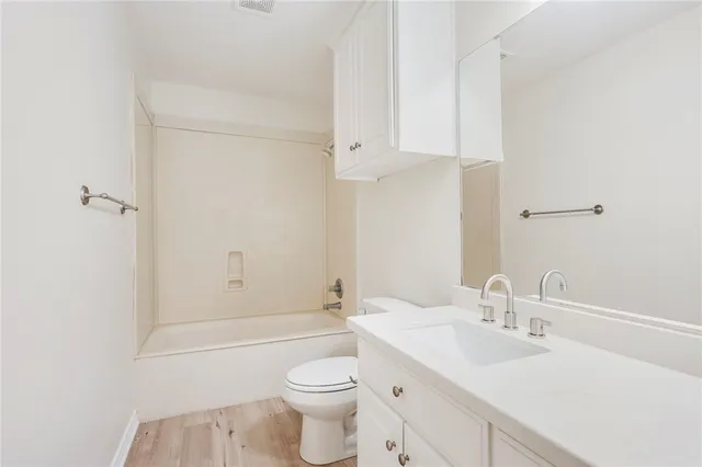 a bathroom with a sink toilet vanity and shower