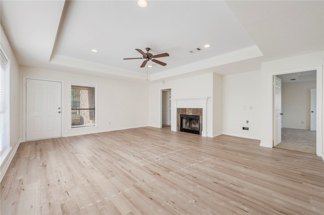 1604 Winfield Court Bryan, TX 77802 - Photo 3 of 14 an empty room with wooden floor fireplace and windows