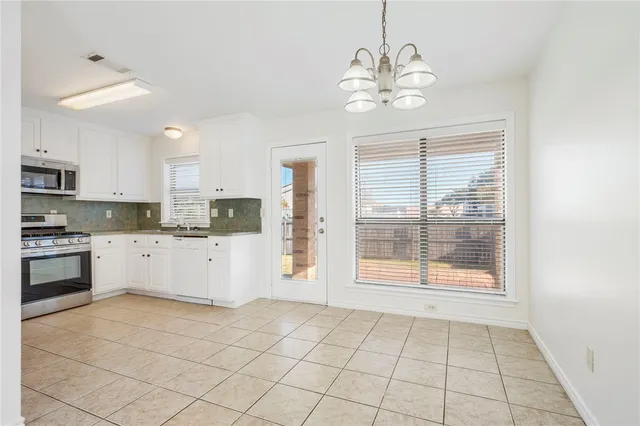 a kitchen with a stove a refrigerator and cabinets