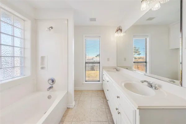 a bathroom with a bathtub a sink and a window