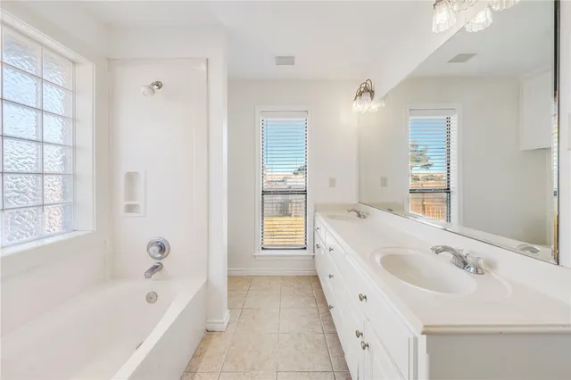 a bathroom with a bathtub a sink and a window