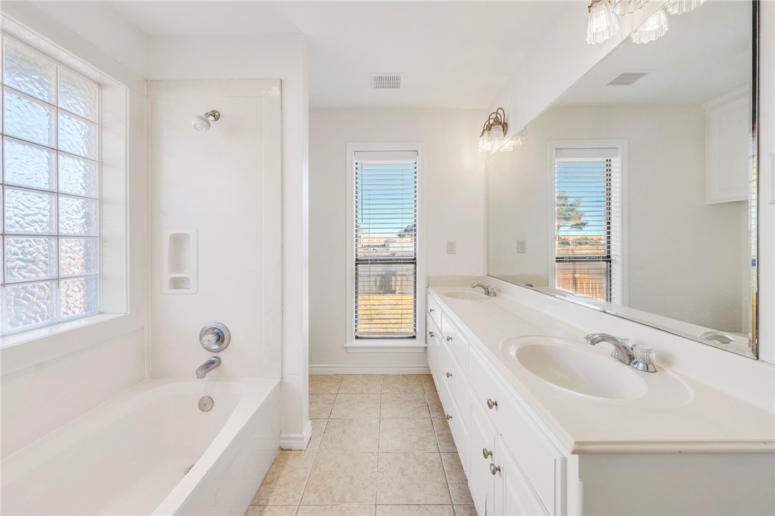 1604 Winfield Court Bryan, TX 77802 - Photo 7 of 14 a bathroom with a bathtub a sink and a window