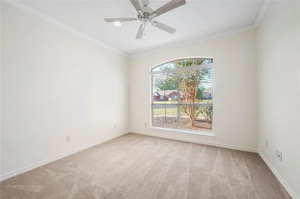 an empty room with a window and a fan