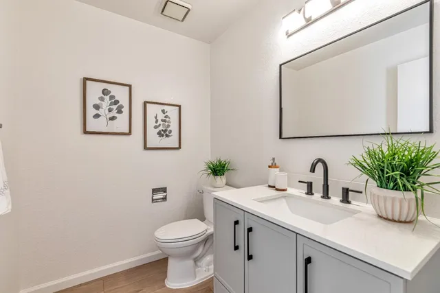 a bathroom with a toilet sink and mirror