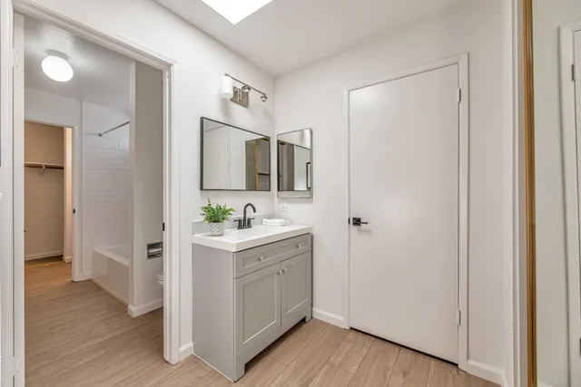 a view of a kitchen from the hallway with closet and wooden floor