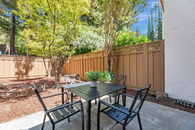 a backyard of a house with table and chairs