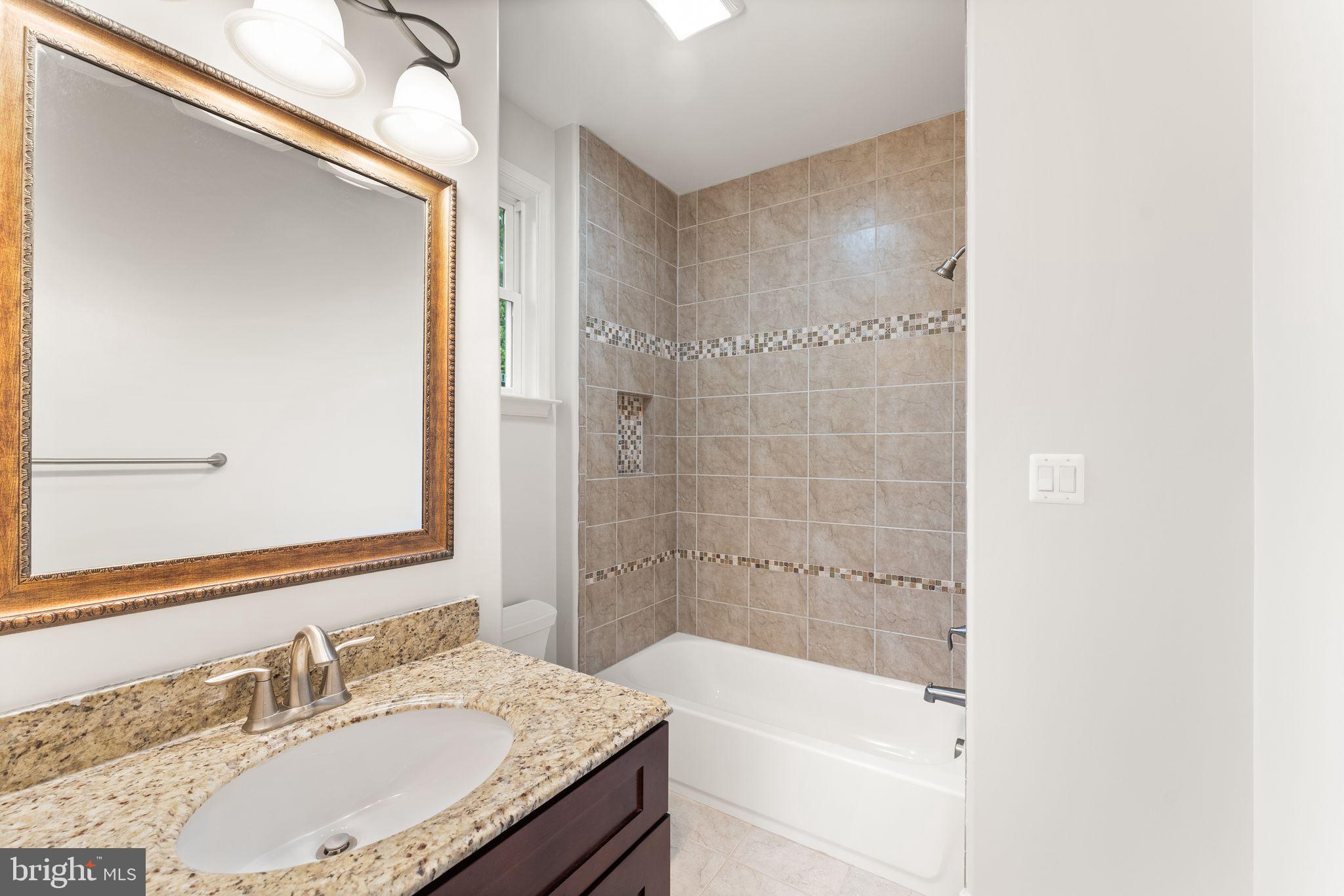 3906 Estel Road Fairfax, VA 22031 - Photo 69 of 122 a bathroom with a granite countertop bathtub shower sink and mirror