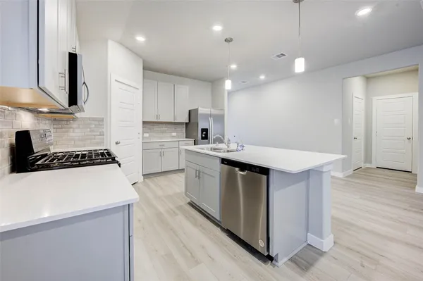a kitchen with a sink a stove a refrigerator and a oven