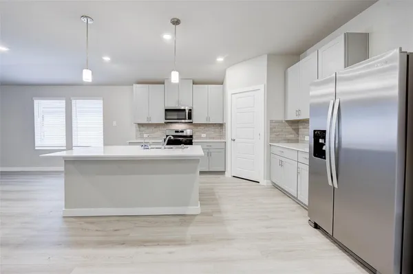 a view of kitchen with white cabinets stainless steel appliances and window