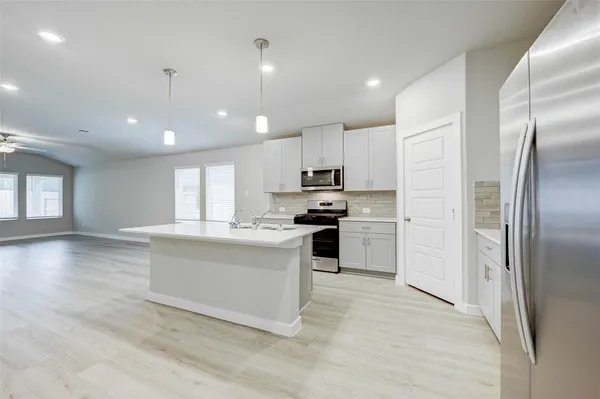 a kitchen with kitchen island white cabinets and stainless steel appliances