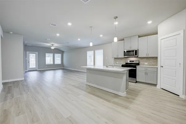 a kitchen with a refrigerator and a stove top oven