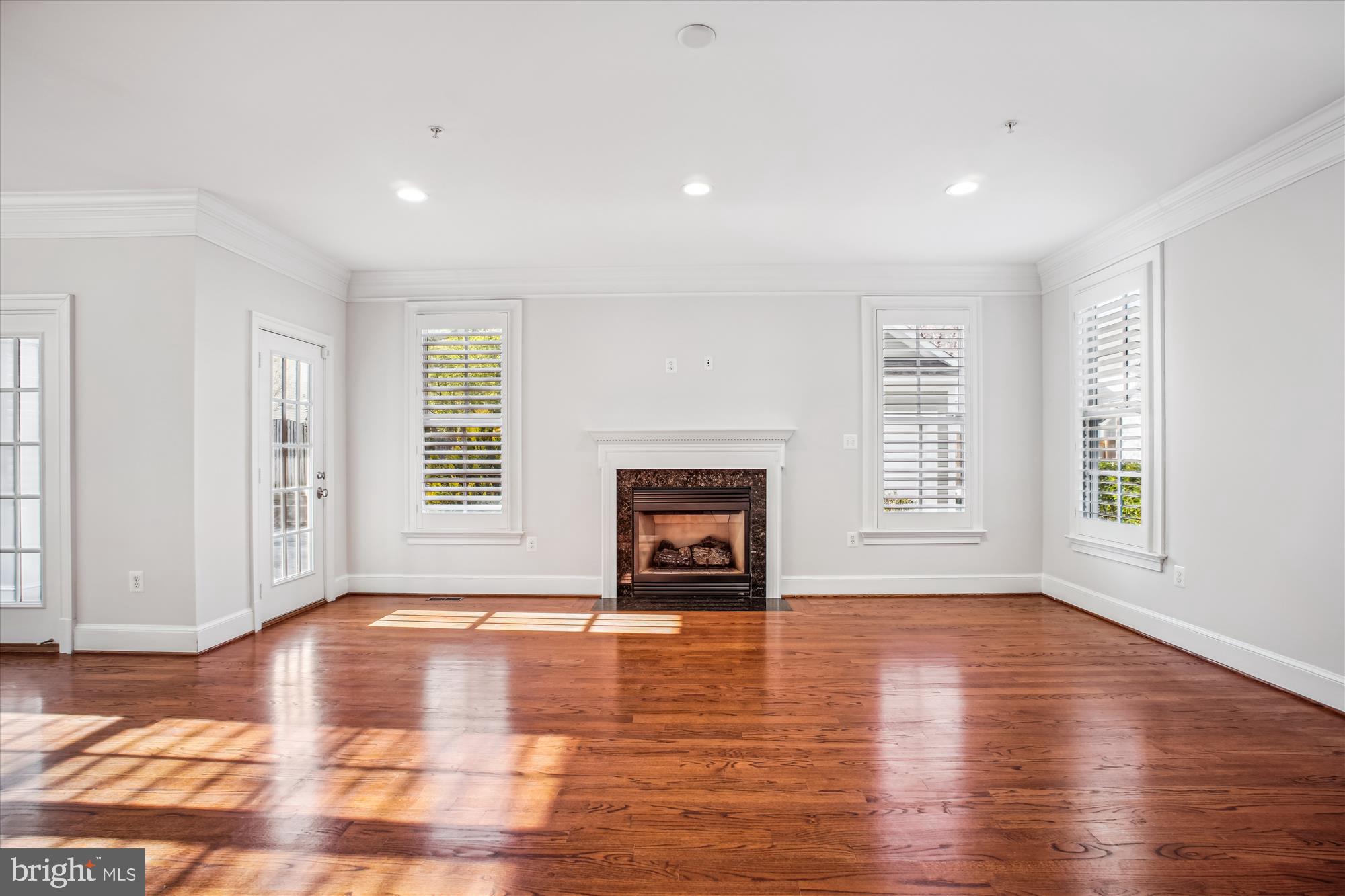 5512 Greentree Road Bethesda, MD 20817 - Photo 21 of 75 an empty room with wooden floor fire place and windows