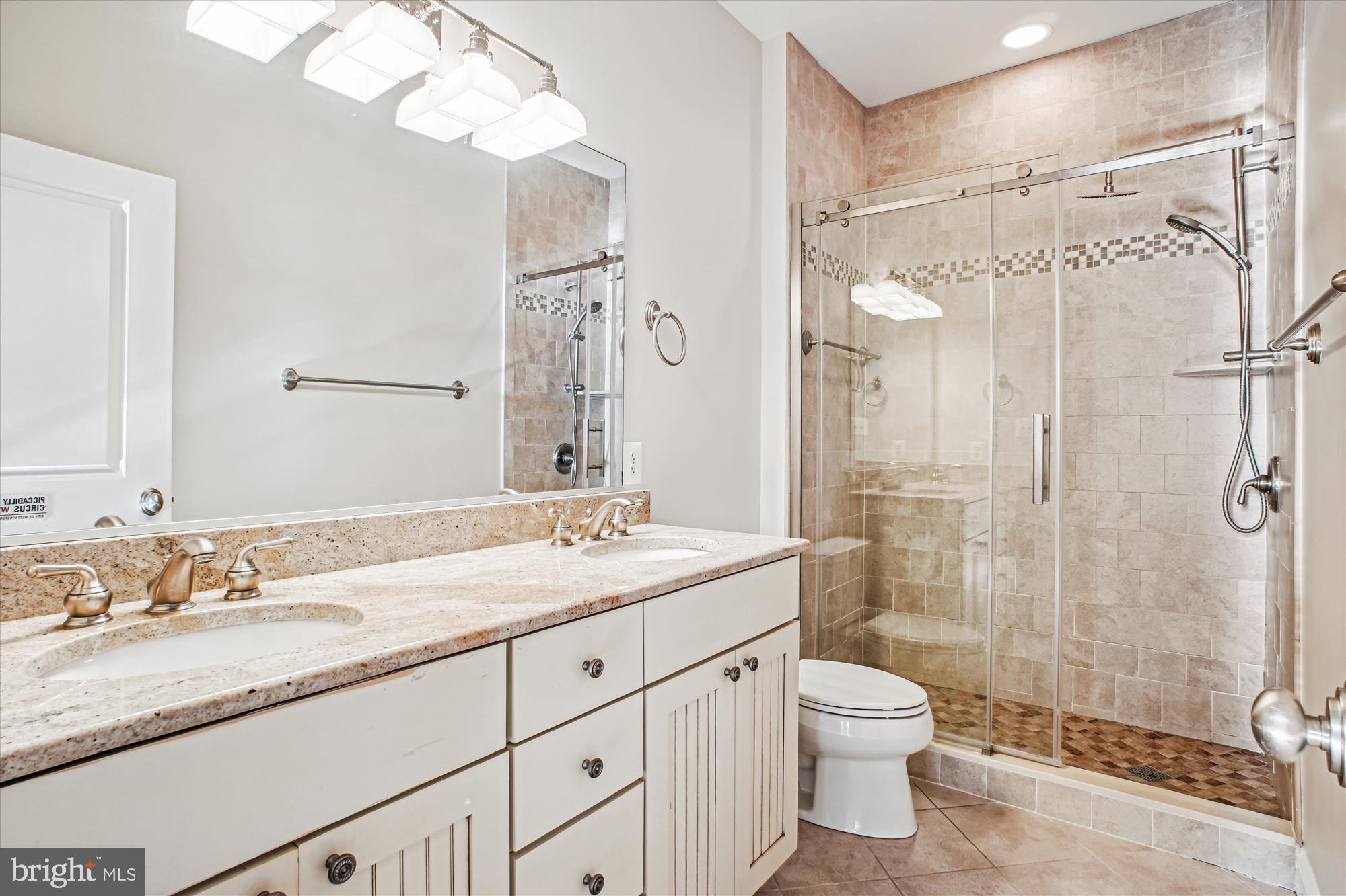5512 Greentree Road Bethesda, MD 20817 - Photo 47 of 75 a bathroom with a granite countertop sink toilet a large mirror a shower and vanity