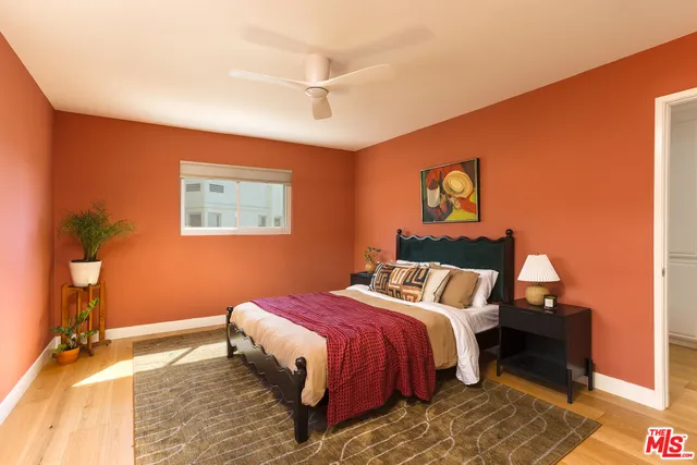 a bedroom with a bed and a painting on the wall