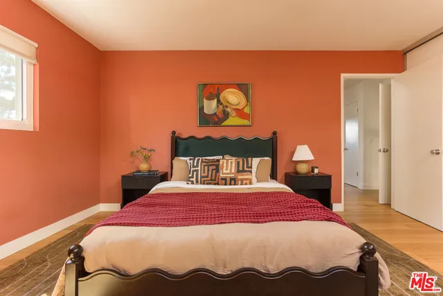 a bedroom with a bed and a painting on the wall