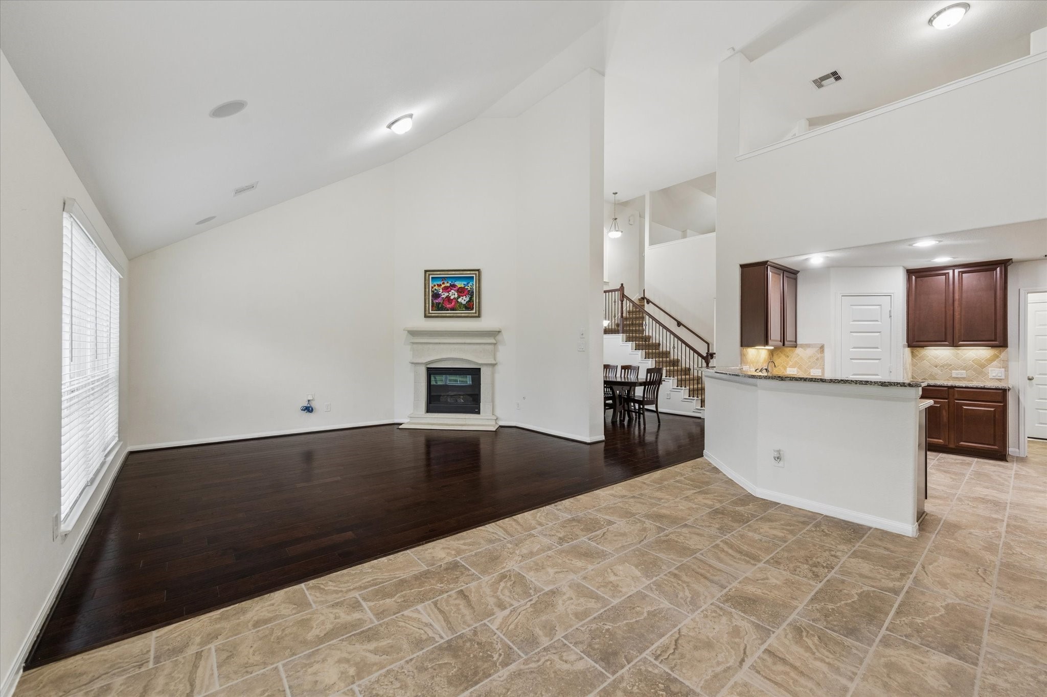 7015 Riata Hills Lane Spring, TX 77379 - Photo 10 of 33 This angle showcases the kitchen and expansive breakfast area, complete with ceramic tile flooring and a thoughtfully designed layout. The open upper-level design allows for seamless communication and an airy, connected feel.