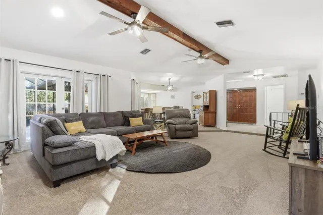a living room with furniture gym equipment and a ceiling fan