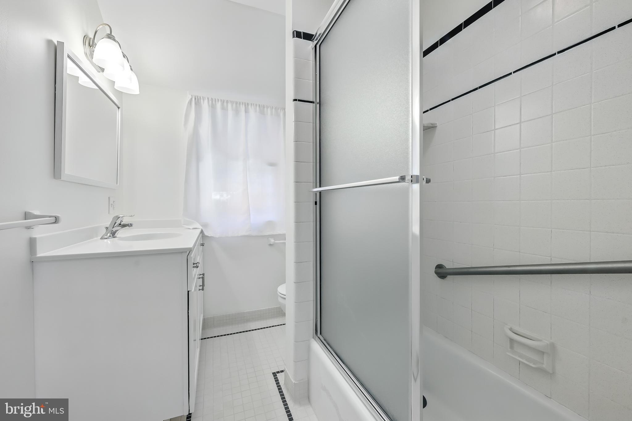 22 Center Meeting Road, Unit B Wilmington, DE 19807 - Photo 13 of 20 a bathroom with a shower sink vanity and a mirror