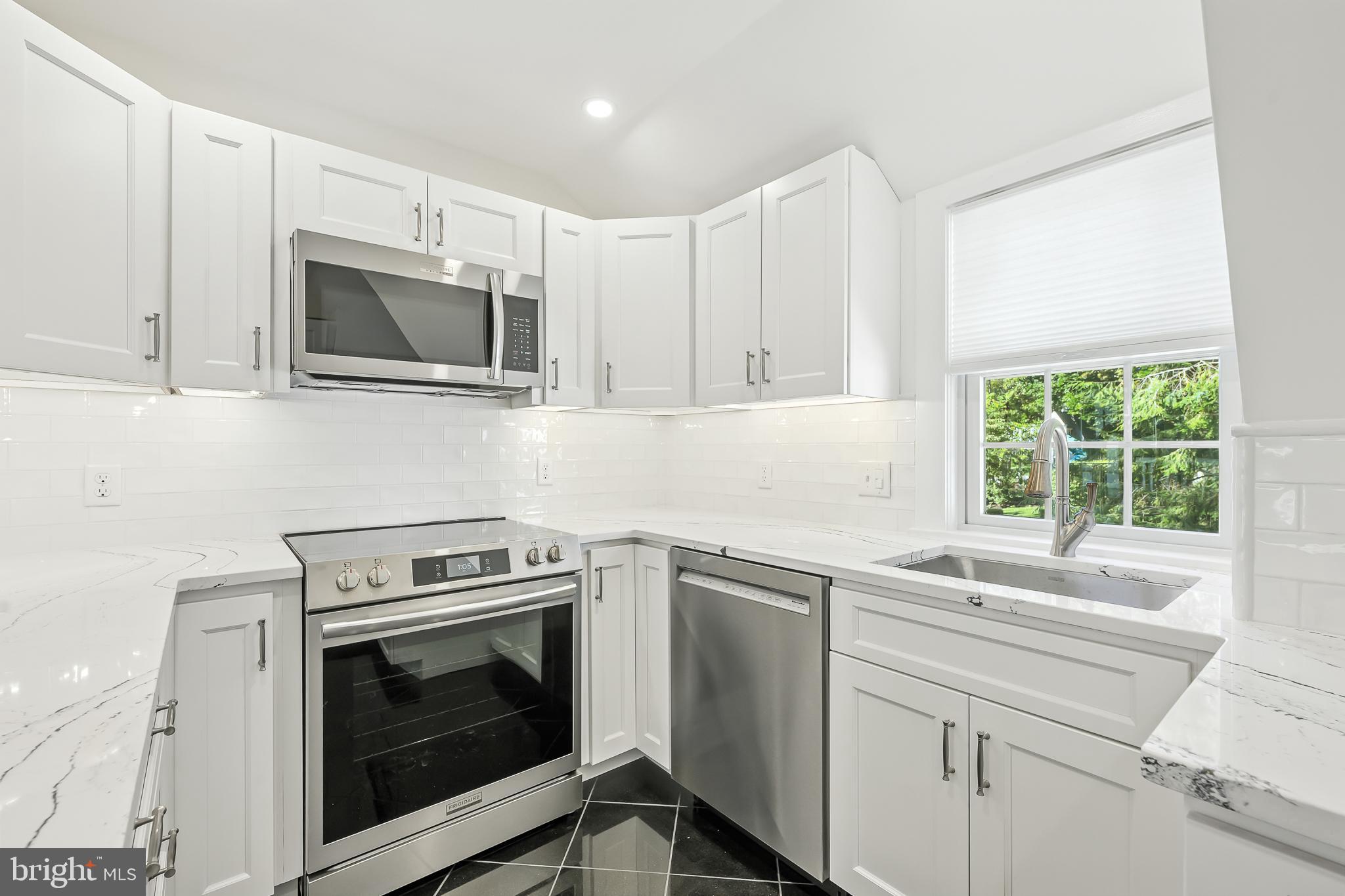 22 Center Meeting Road, Unit B Wilmington, DE 19807 - Photo 5 of 20 a kitchen with a stove microwave and sink