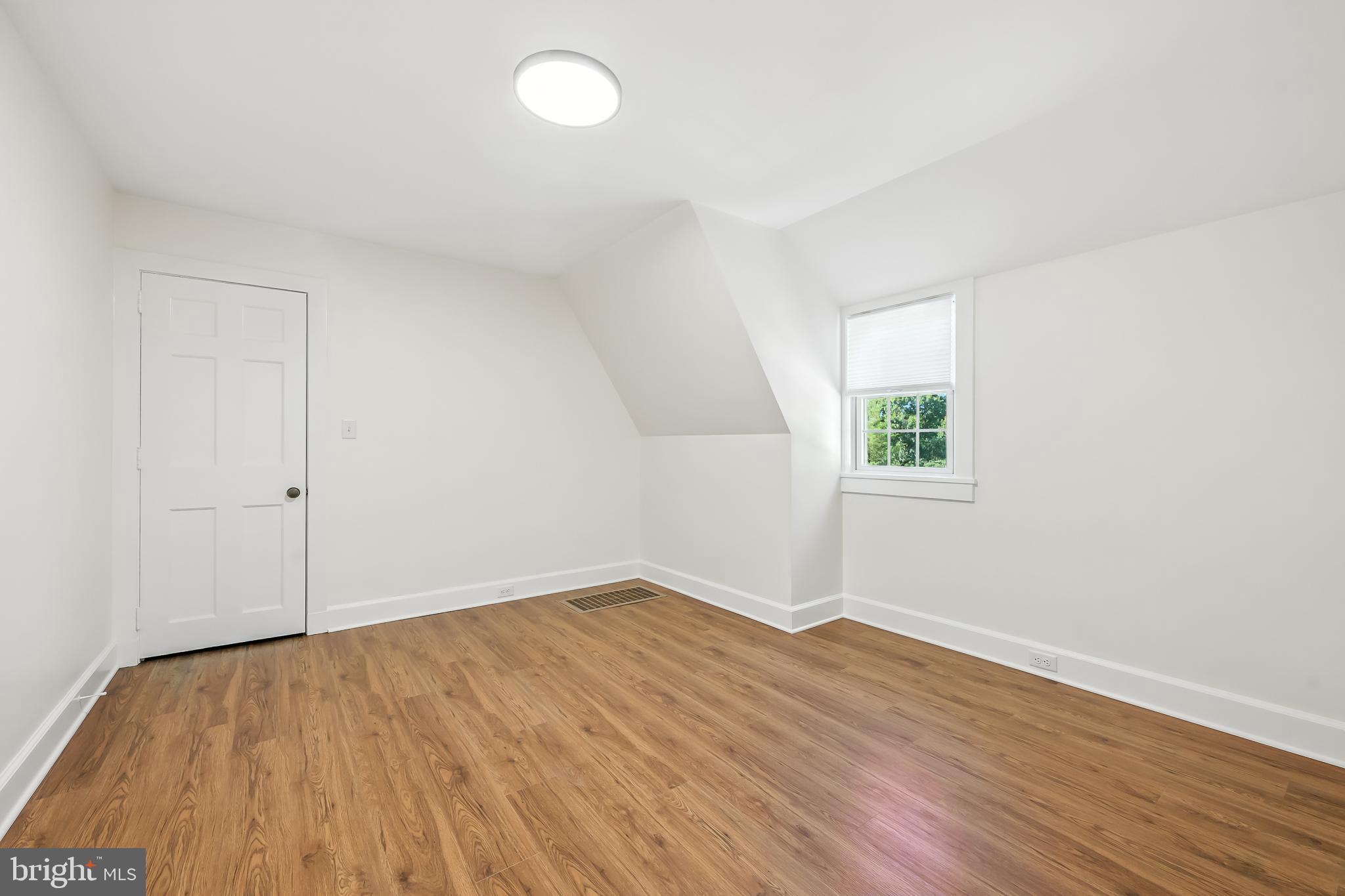 22 Center Meeting Road, Unit B Wilmington, DE 19807 - Photo 10 of 20 an empty room with wooden floor and windows