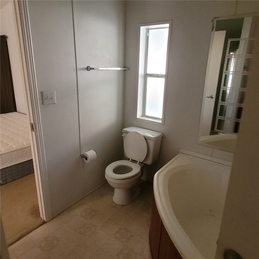 9732 2nd Street Chloride, AZ 86431 - Photo 18 of 28 Bathroom featuring a toilet, a window with frosted glass, and a vanity with a white sink