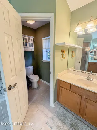 a bathroom with a granite countertop sink mirror vanity and toilet