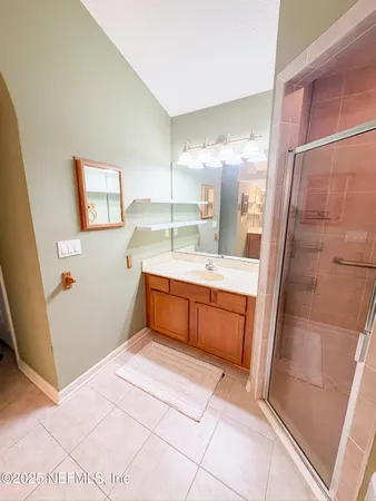 a bathroom with a tub sink vanity granite and a mirror